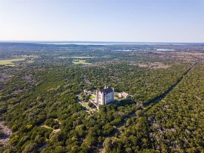 Aerial view with European castle architecture at 7400 Park Road 4 S - 7 bed 4 bath home