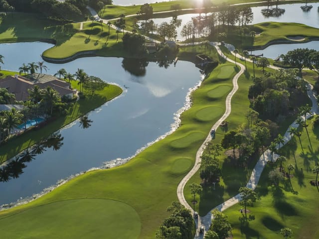 Aerial view of golf-course greens, water hazards, cart paths, and homes