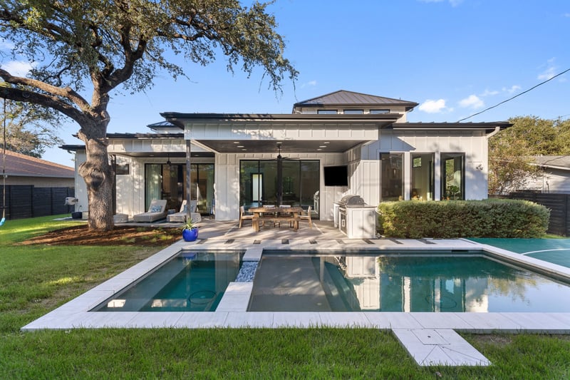 7311 Running Rope: the rear of the home across the pool and spa, with the covered patio and outdoor kitchen